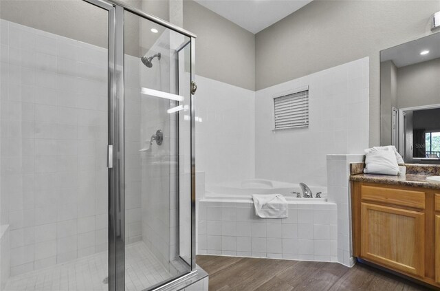 bathroom featuring independent shower and bath, vanity, and hardwood / wood-style flooring