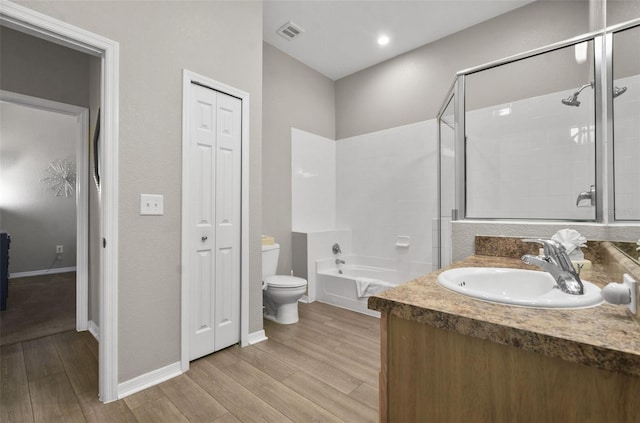 full bathroom featuring plus walk in shower, hardwood / wood-style flooring, vanity, and toilet