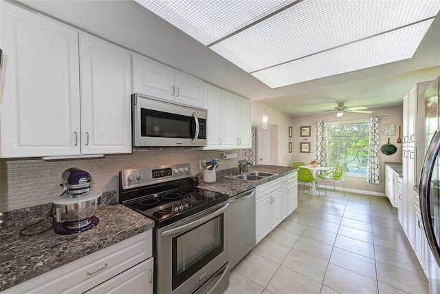 kitchen featuring backsplash, stainless steel appliances, hanging light fixtures, and white cabinets