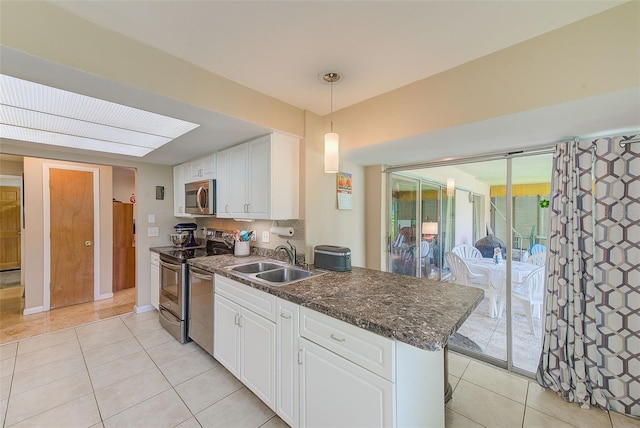 kitchen with sink, white cabinetry, hanging light fixtures, and stainless steel appliances