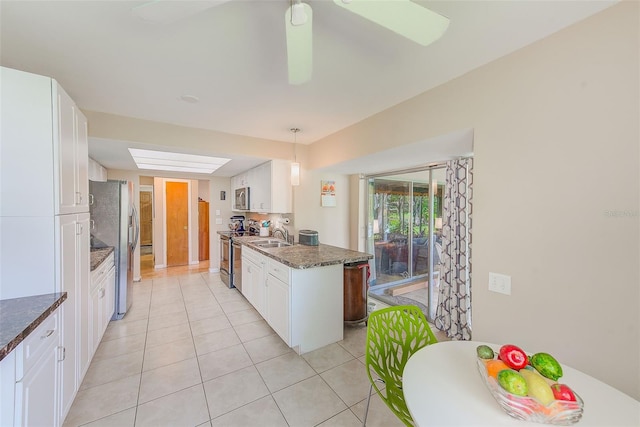 kitchen with hanging light fixtures, appliances with stainless steel finishes, and white cabinets