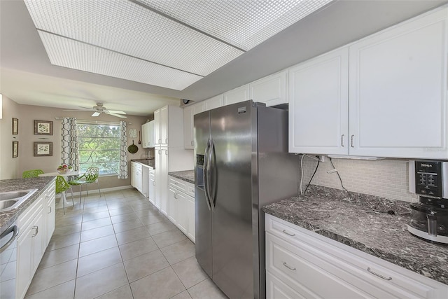 kitchen featuring backsplash, white cabinets, light tile patterned floors, appliances with stainless steel finishes, and ceiling fan