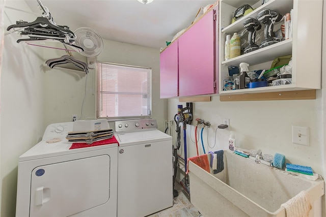 laundry area featuring sink, washing machine and dryer, and cabinets