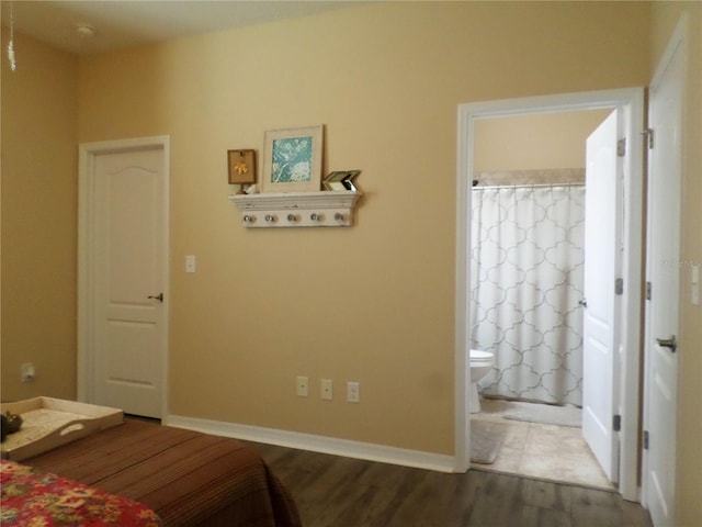 bedroom with hardwood / wood-style flooring and ensuite bathroom