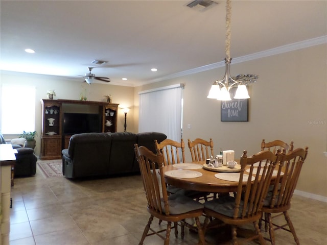 tiled dining space featuring ceiling fan with notable chandelier and ornamental molding