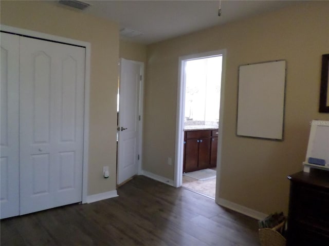 unfurnished bedroom with a closet and dark wood-type flooring