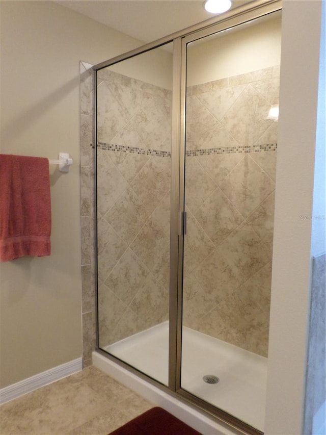 bathroom with tile patterned flooring and a shower with door