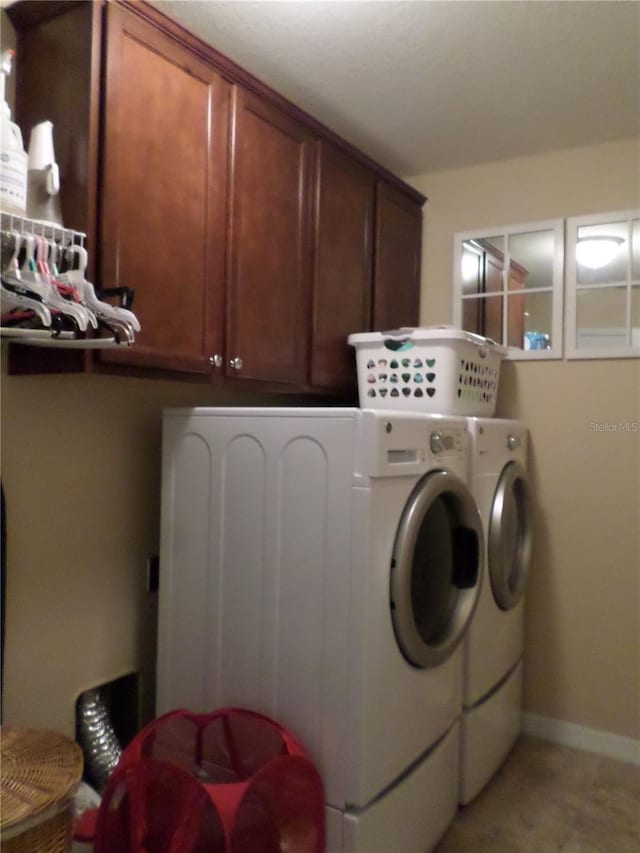 clothes washing area with cabinets and independent washer and dryer