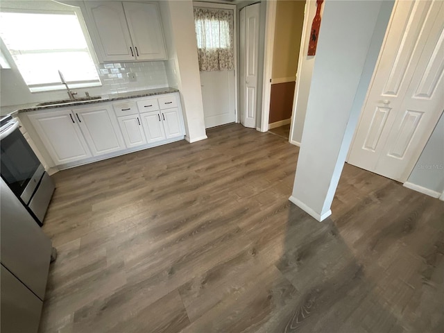 kitchen featuring decorative backsplash, white cabinets, stone countertops, and dark wood-type flooring