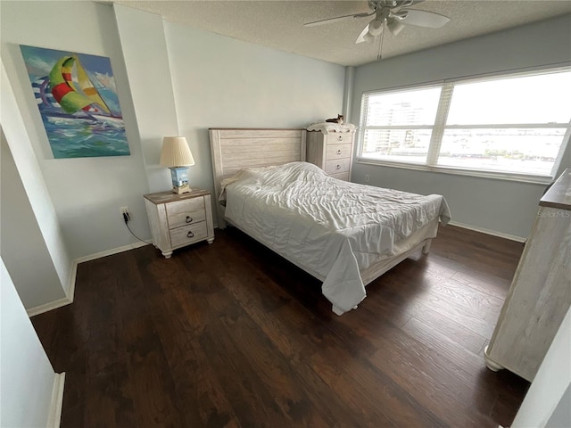 bedroom featuring ceiling fan, dark wood-type flooring, and a textured ceiling