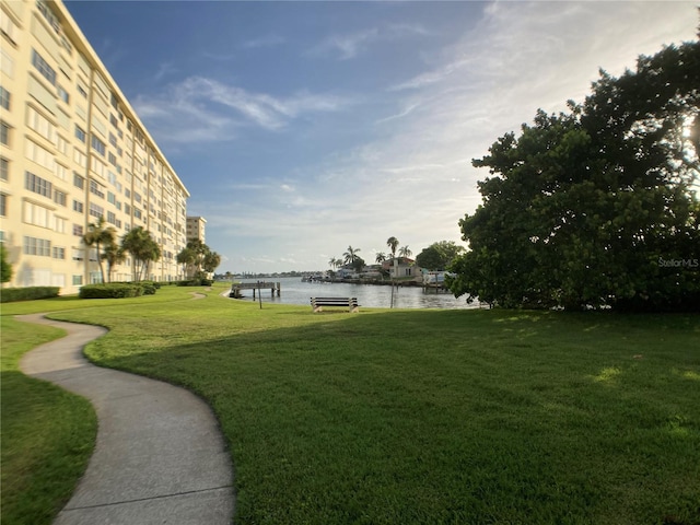 view of home's community with a water view and a yard