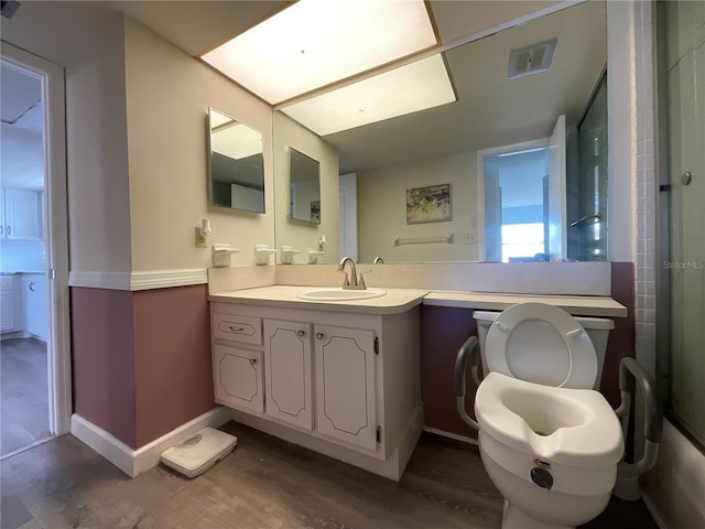 bathroom with wood-type flooring, vanity, and toilet