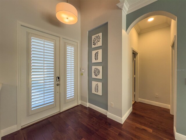 4977 Sapphire Sound Dr, Wimauma, FL 33598 - doorway to outside featuring arched walkways, crown molding, dark wood-style flooring, and baseboards