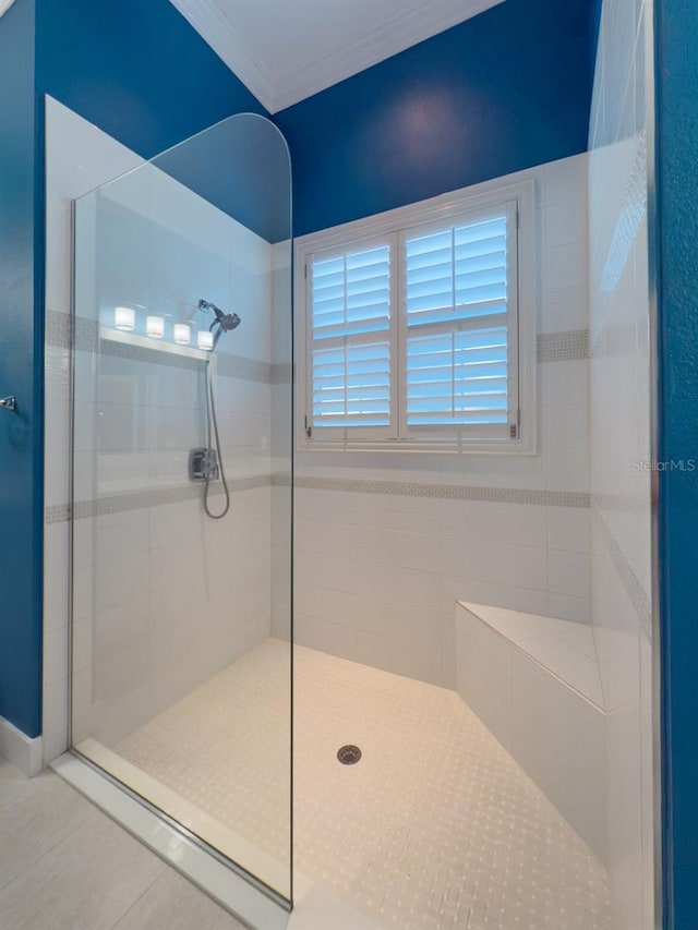 bathroom featuring a tile shower, tile patterned floors, and crown molding