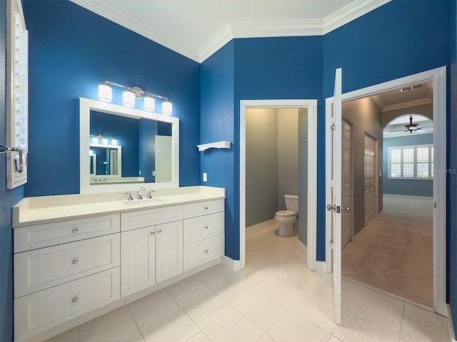 bathroom featuring ceiling fan, tile patterned flooring, crown molding, toilet, and vanity