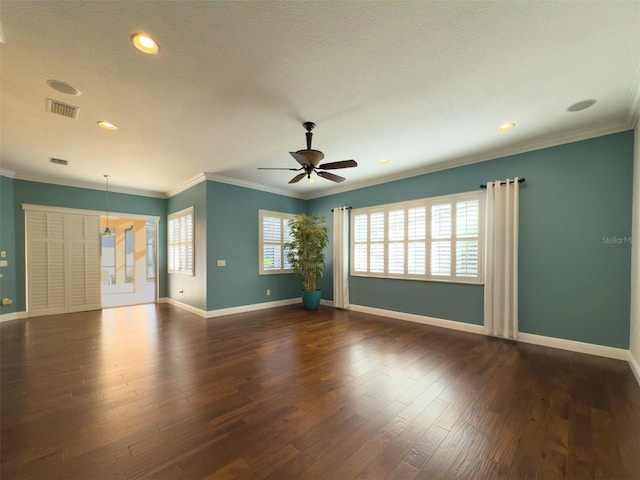 empty room featuring dark hardwood / wood-style flooring, ceiling fan, and ornamental molding