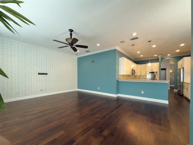 unfurnished living room featuring a textured ceiling, crown molding, ceiling fan, and dark wood-type flooring