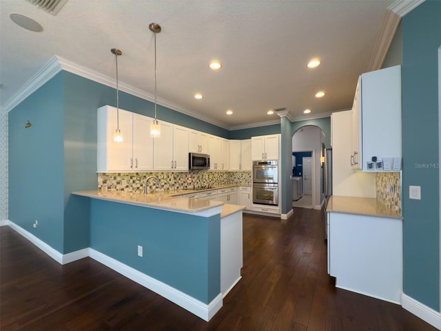 kitchen featuring kitchen peninsula, decorative light fixtures, dark hardwood / wood-style flooring, white cabinetry, and stainless steel appliances