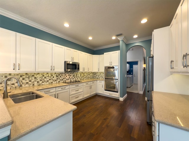 kitchen featuring white cabinetry, sink, light stone countertops, dark hardwood / wood-style floors, and appliances with stainless steel finishes