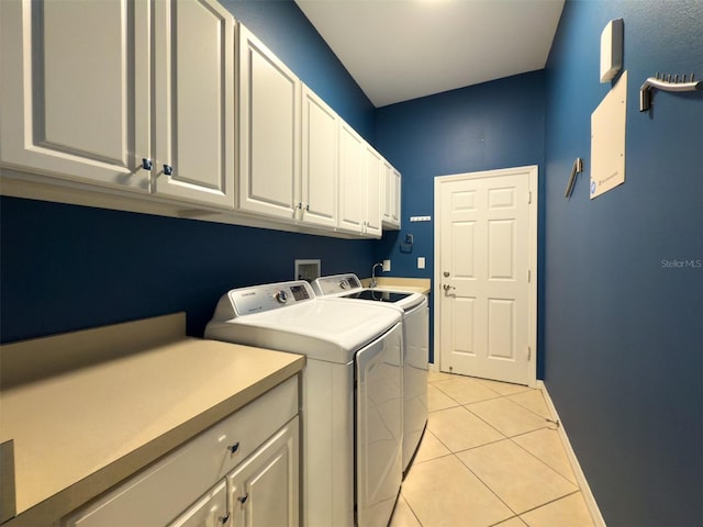 laundry room with cabinets, washing machine and dryer, and light tile patterned floors