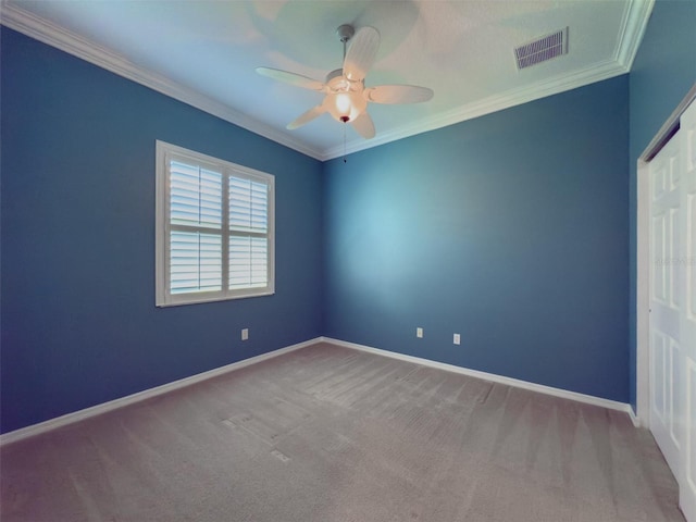 carpeted empty room with ceiling fan and crown molding