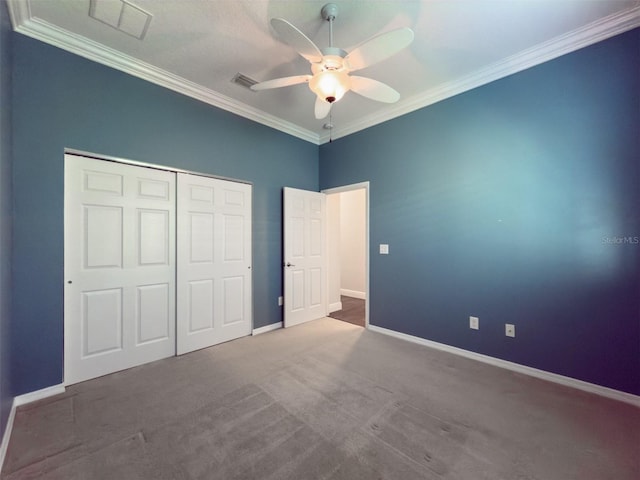 unfurnished bedroom featuring ceiling fan, a closet, carpet floors, and crown molding