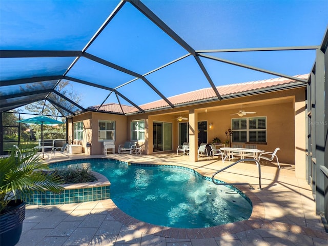 view of swimming pool featuring glass enclosure, ceiling fan, and a patio area