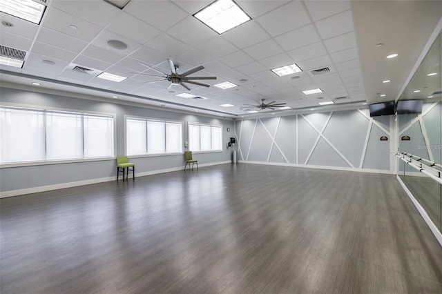 unfurnished room with a drop ceiling, ceiling fan, and dark wood-type flooring