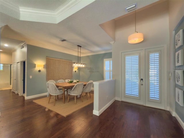 dining space with crown molding, a healthy amount of sunlight, baseboards, visible vents, and wood finished floors