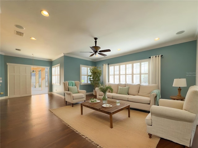 living room featuring baseboards, ornamental molding, visible vents, and wood finished floors