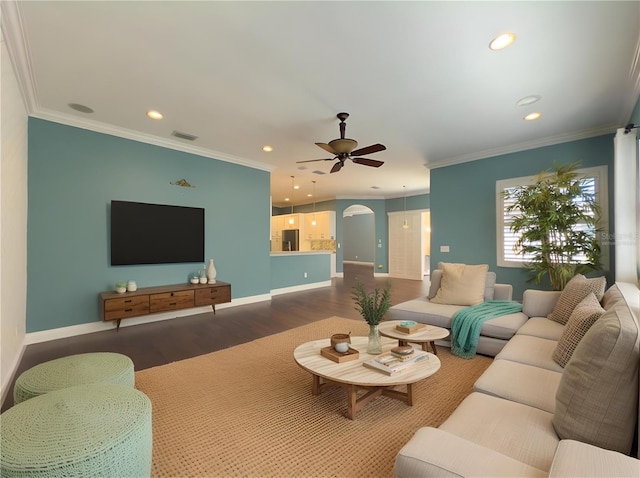 living area with ornamental molding, dark wood-style floors, baseboards, and ceiling fan