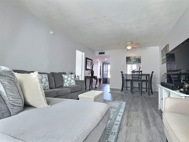 living room featuring ceiling fan and dark hardwood / wood-style flooring