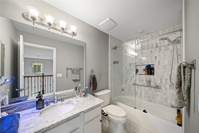 full bathroom featuring vanity, a textured ceiling, enclosed tub / shower combo, and toilet