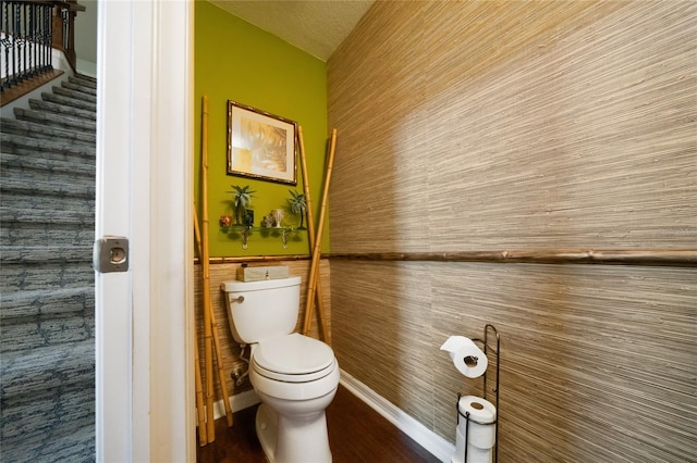 bathroom with wood walls and toilet