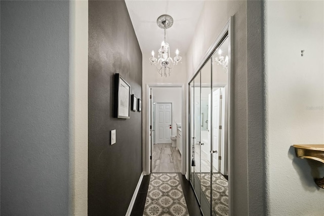 2539 Silverback Ct, Palm Harbor, FL 34684 - corridor featuring baseboards and a notable chandelier