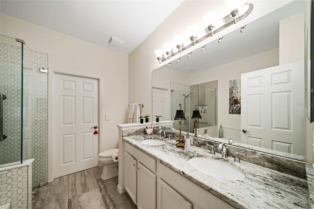 2539 Silverback Ct, Palm Harbor, FL 34684 - bathroom with a stall shower, double vanity, toilet, and a sink
