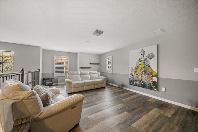 living room with wood-type flooring and a textured ceiling