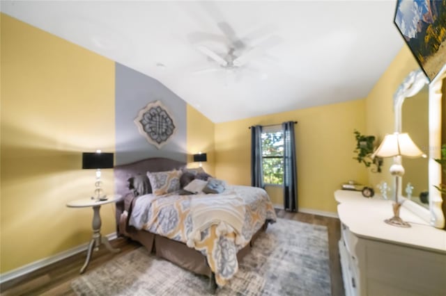 bedroom with ceiling fan, hardwood / wood-style flooring, and vaulted ceiling