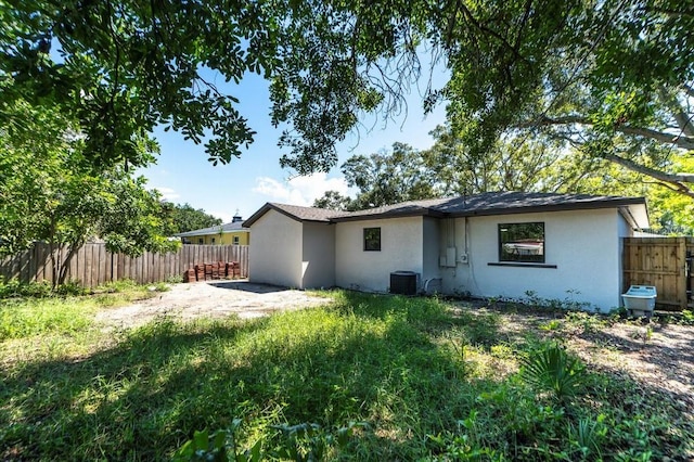 rear view of property featuring central AC, a patio area, and a yard