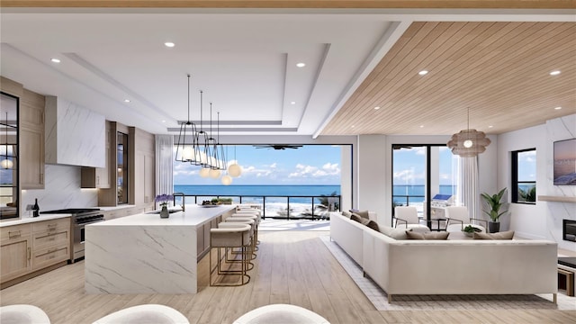 living room with light wood-type flooring, an inviting chandelier, and a high end fireplace