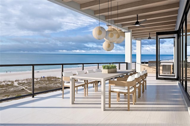 balcony featuring a water view, a beach view, and ceiling fan