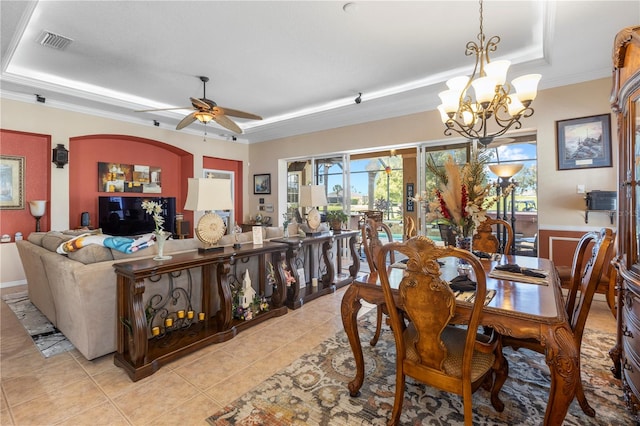 dining area featuring a tray ceiling, light tile patterned flooring, ceiling fan with notable chandelier, and ornamental molding