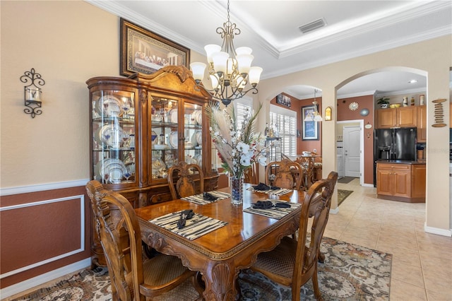 dining area with an inviting chandelier, ornamental molding, and light tile patterned flooring