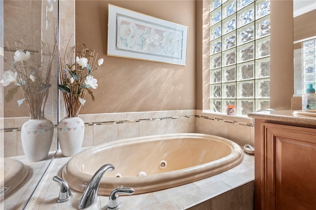 bathroom with vanity, plenty of natural light, crown molding, and tiled tub