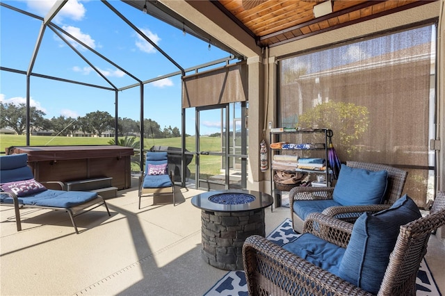 view of patio featuring glass enclosure and a hot tub