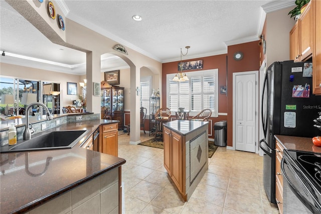 kitchen featuring a textured ceiling, a healthy amount of sunlight, ornamental molding, and sink