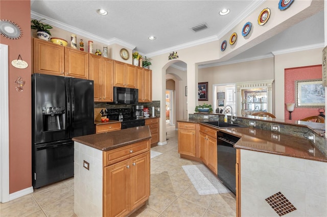 kitchen featuring sink, a center island, crown molding, and black appliances