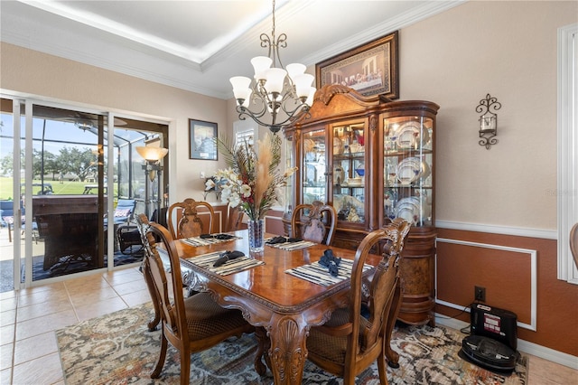 dining area with light tile patterned flooring, ornamental molding, and an inviting chandelier