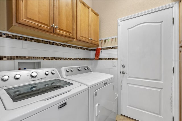 laundry room with cabinets and washer and clothes dryer