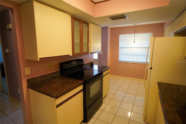 kitchen featuring hanging light fixtures, light tile patterned floors, black electric range, dark stone counters, and white fridge